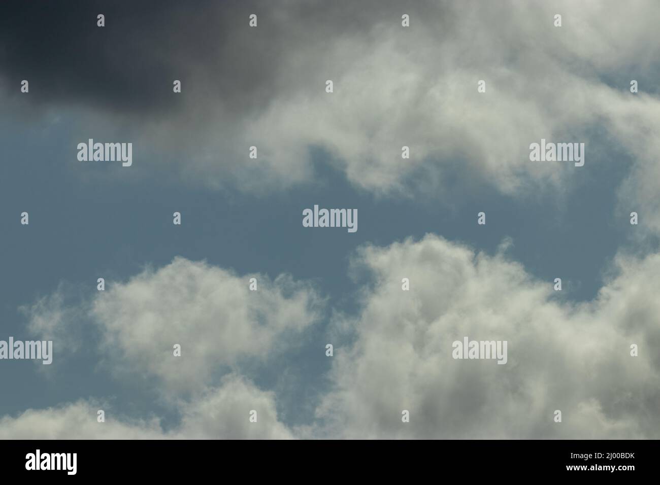 puffy storm clouds gathering against blue sky Stock Photo