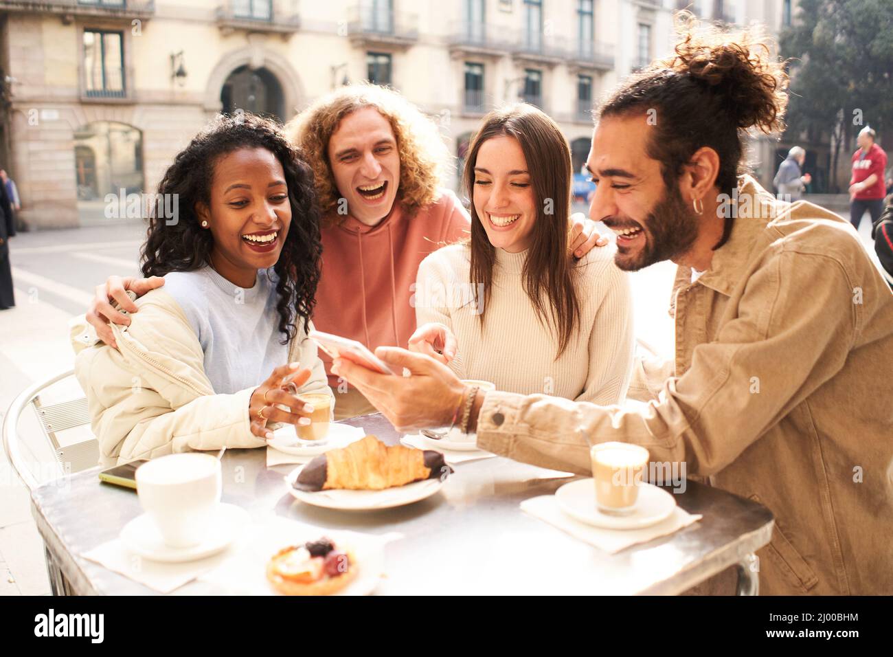 Friends laughing mobile device watching hi-res stock photography and ...