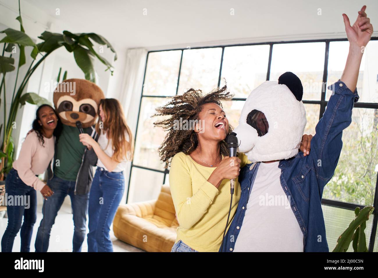 Group of people singing in home karaoke Stock Photo