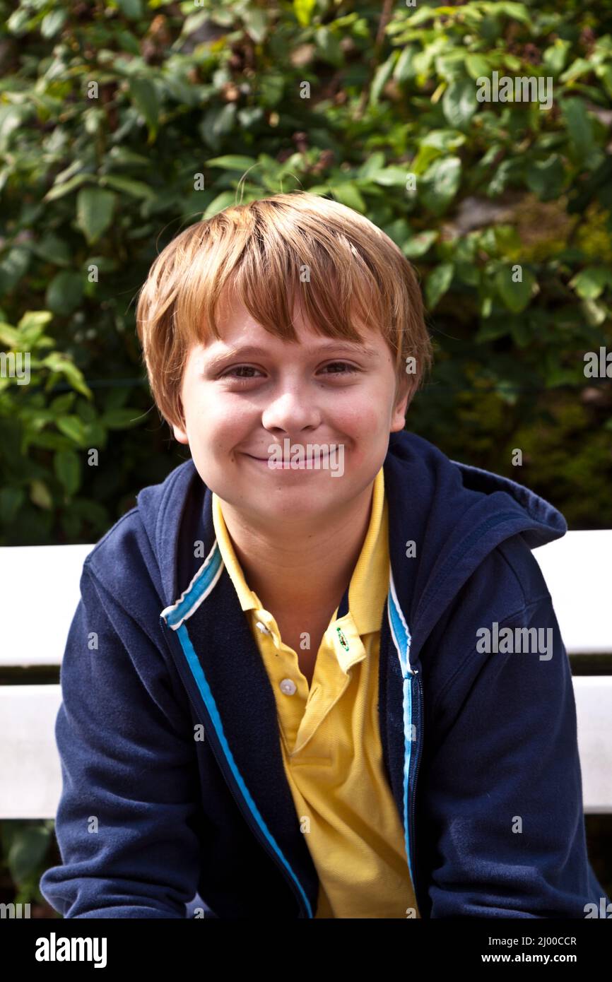 boy sitting on a bench in a park Stock Photo - Alamy