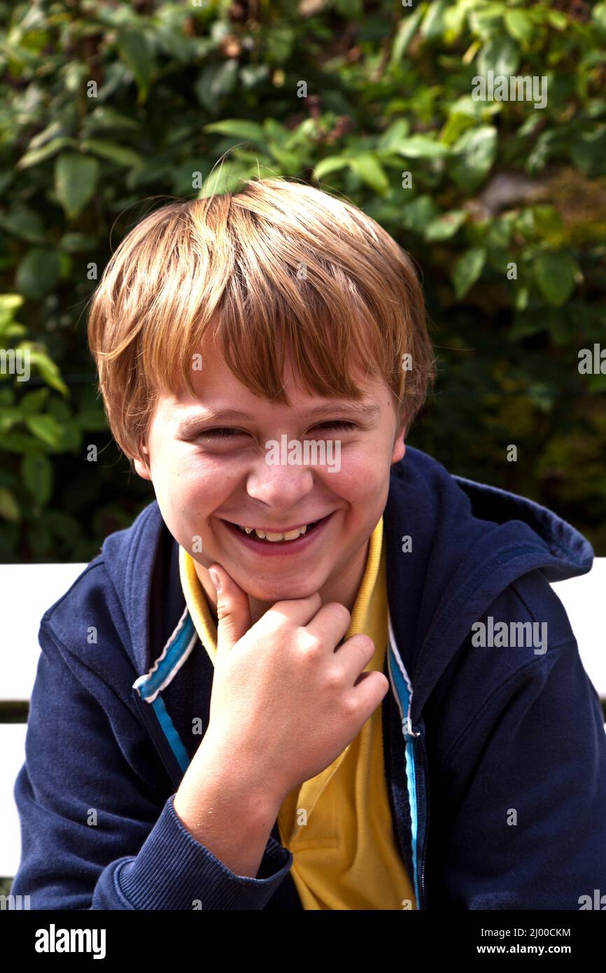 boy sitting on a bench in a park Stock Photo - Alamy