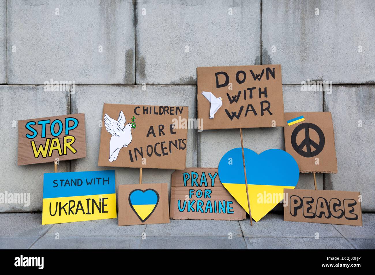 Different posters with messages against Russia's war with Ukraine isolated on a wall. No people. Concept of solidarity and support for the Ukrainian p Stock Photo