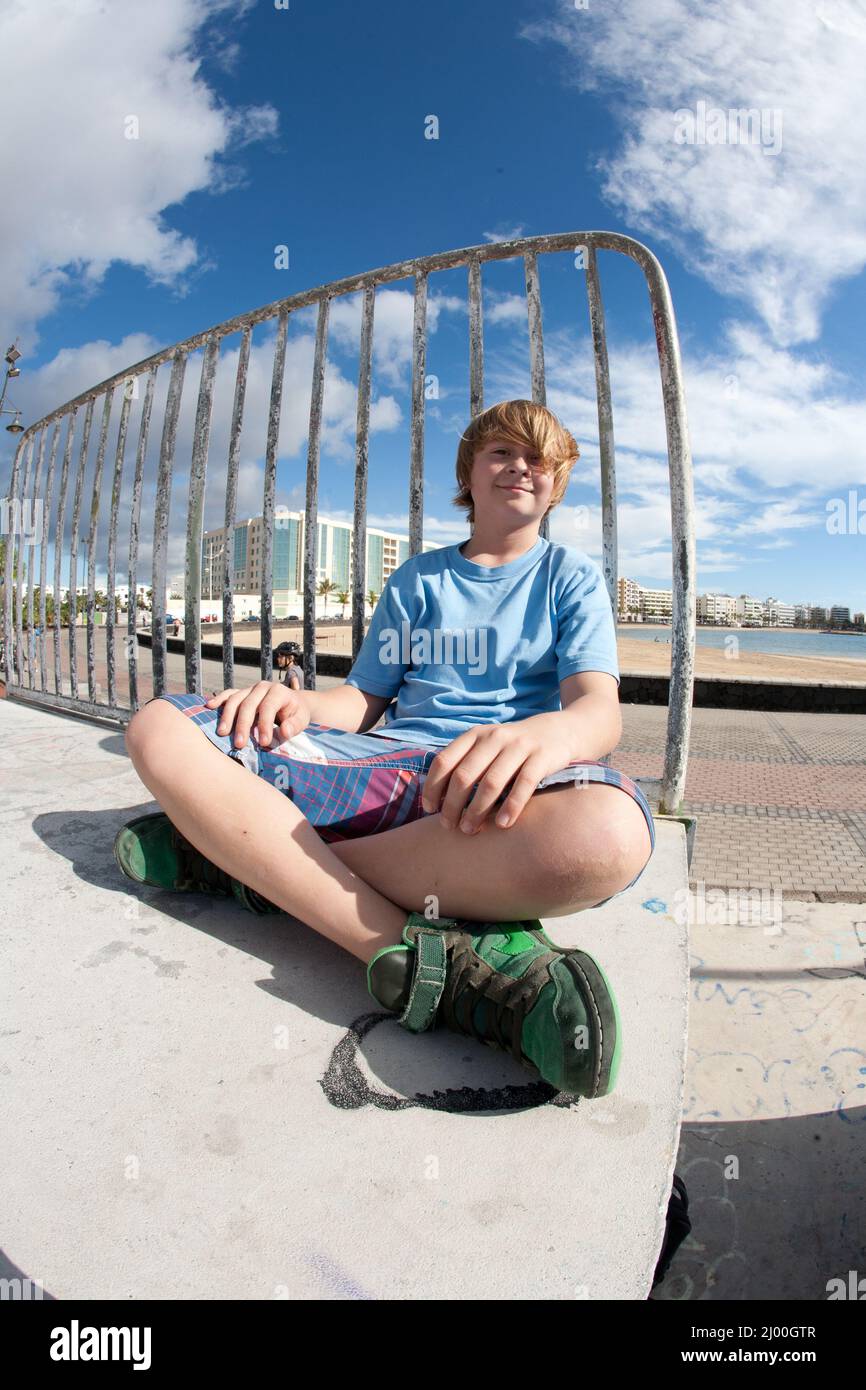 Boys Ramp cute boy is sitting on a ramp at the skate park and smiles Stock Photo ...