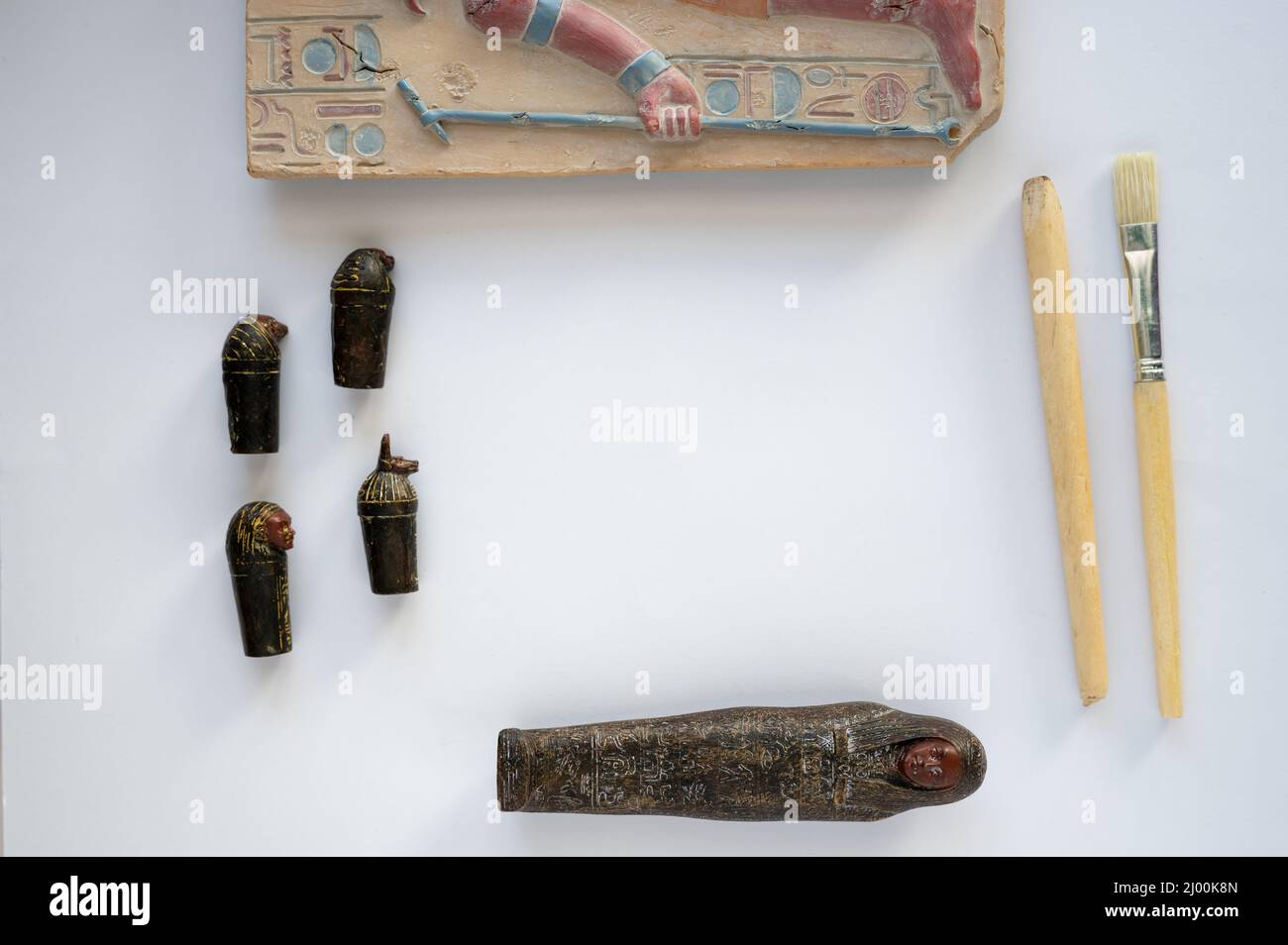 Calgary, Alberta - March 15, 2022:  Toy Egyptian sarcophagus with archeologits tools on white background. Stock Photo