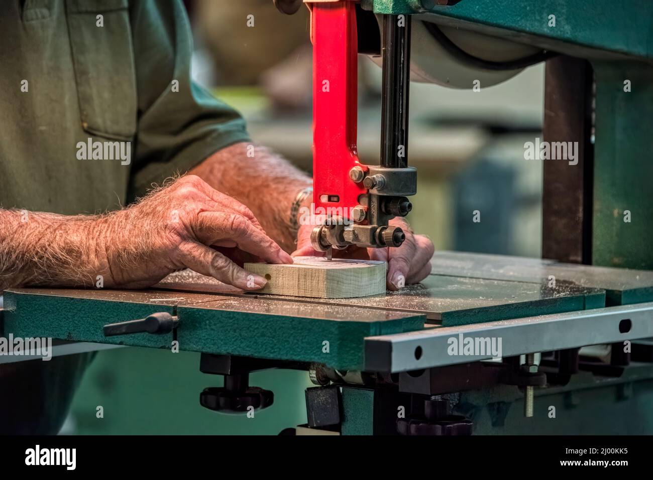 A wood worker makes an intricate cut using a bandsaw in The Villages