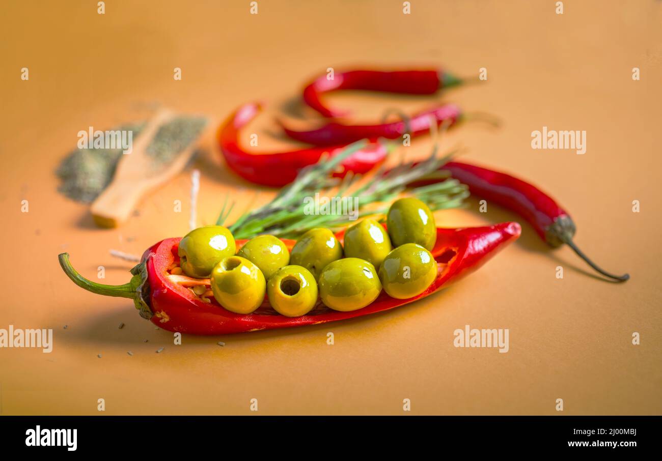 Still life composition of green olives, red hot chilly and spices Stock Photo