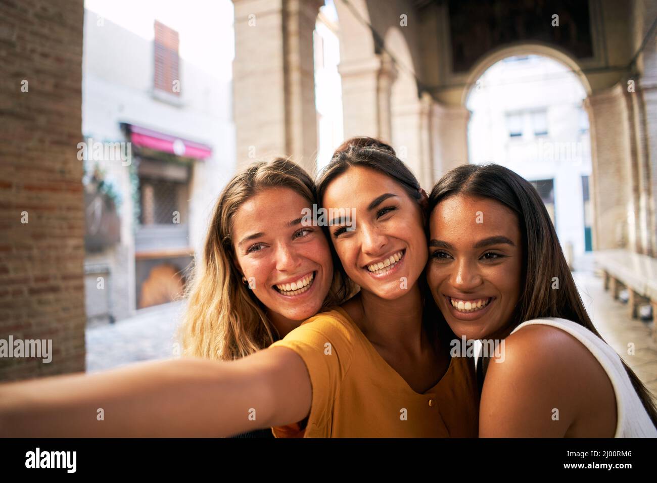 three happy female friends having fun together and taking smiling selfie Stock Photo