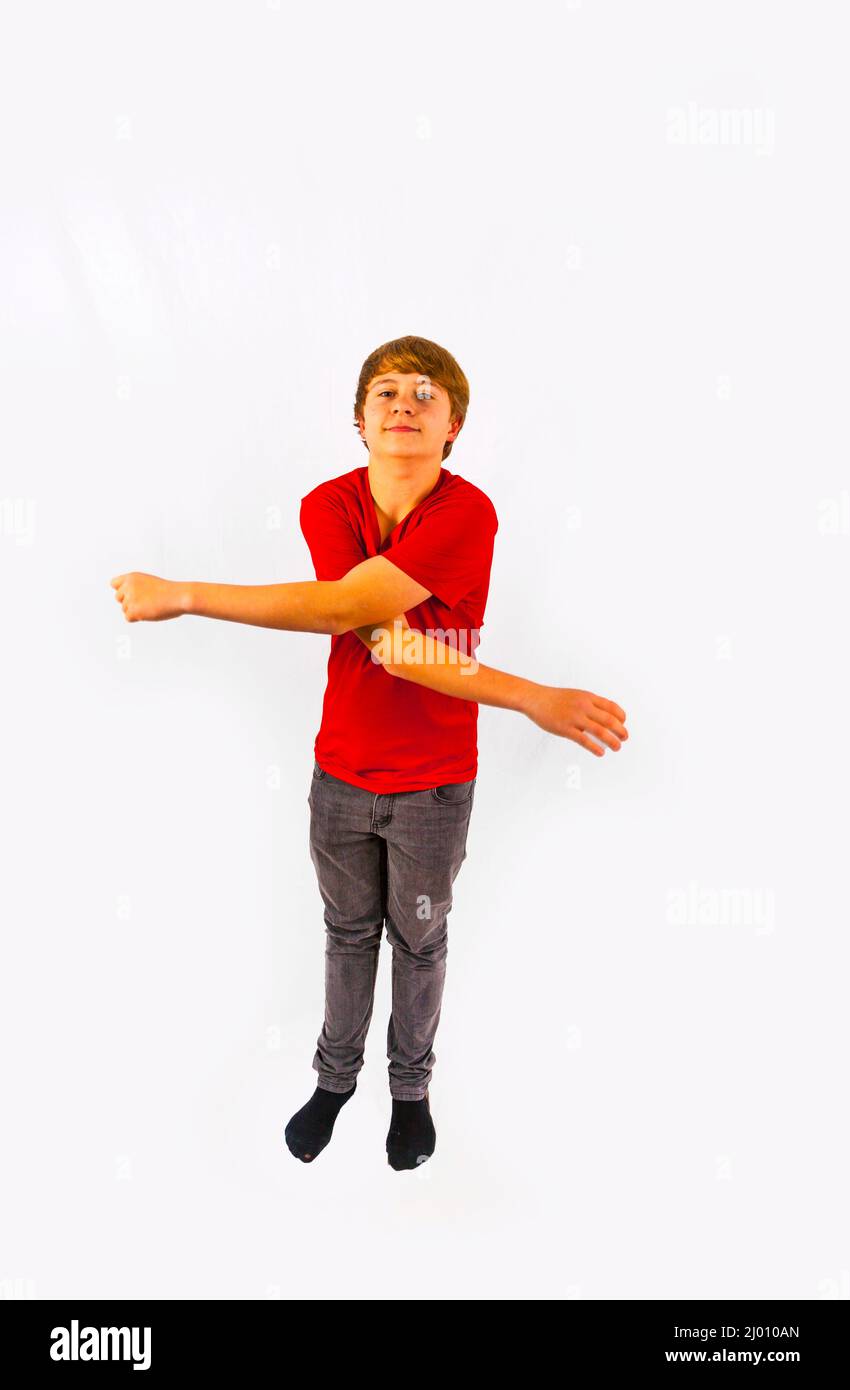 handsome boy has fun gesturing with the arms in the studio Stock Photo