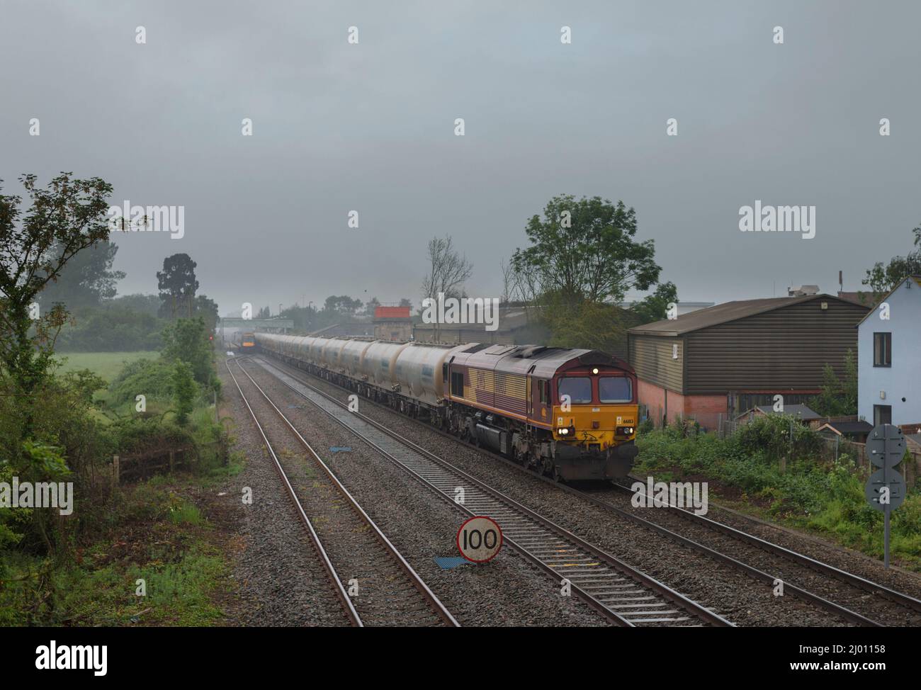 DB Cargo rail UK class 66 locomotive 66183 passing Ashchurch for Tewkesbury with a freight train of empty Castle cement tanks Stock Photo