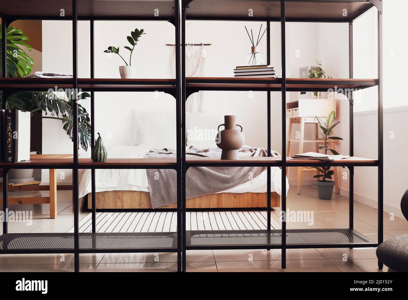 Interior of light bedroom with black bookcase Stock Photo Alamy
