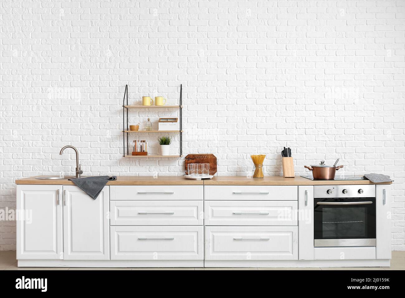 Interior of modern kitchen with white counters and empty glasses Stock ...