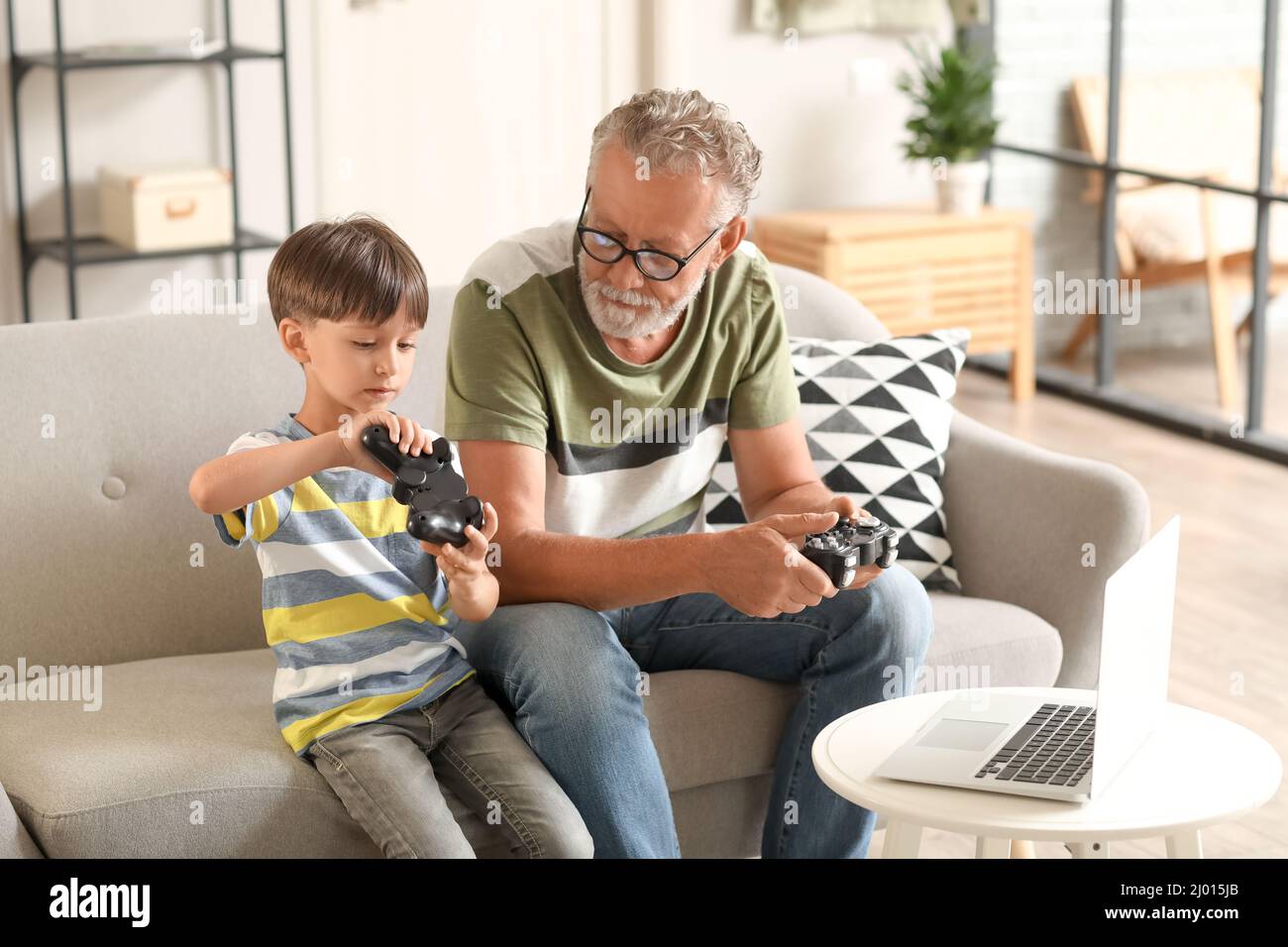Little boy with his grandfather playing video game at home Stock Photo ...
