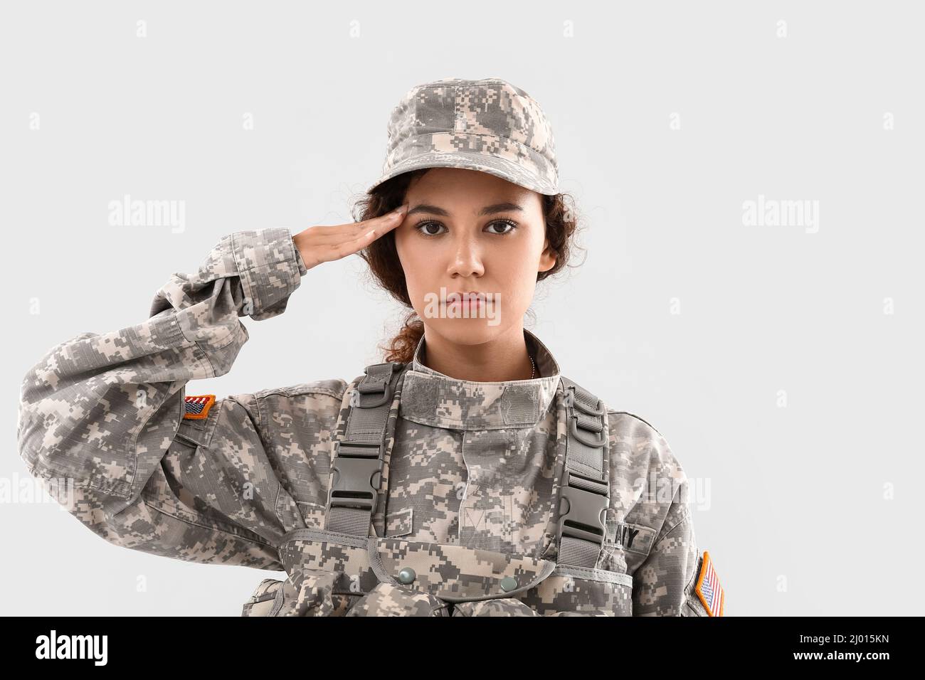 Saluting African-American female soldier on light background Stock ...