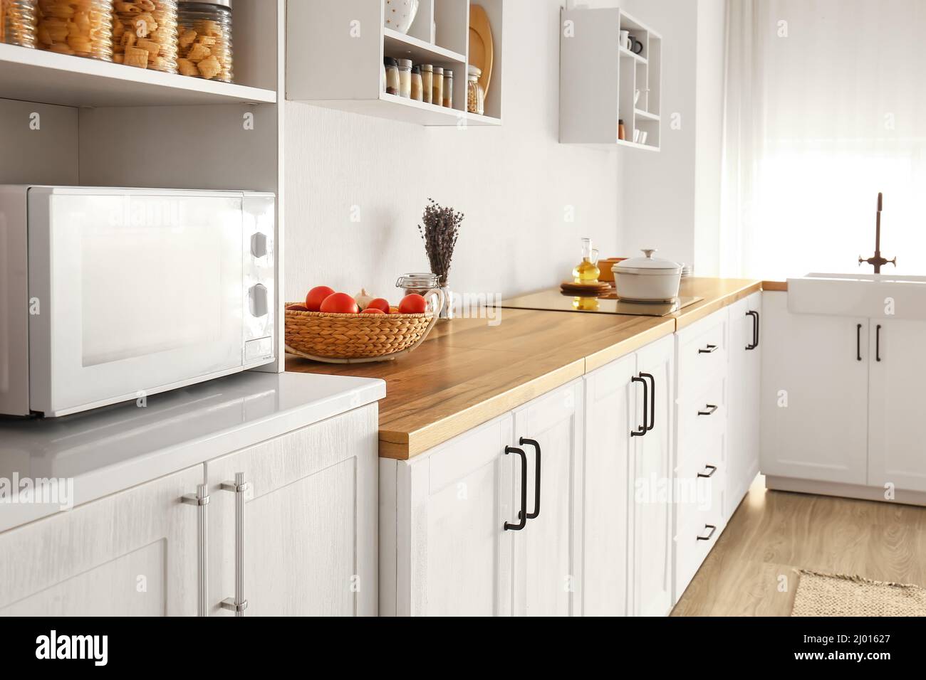 Interior of light modern kitchen with white counters and basket Stock ...