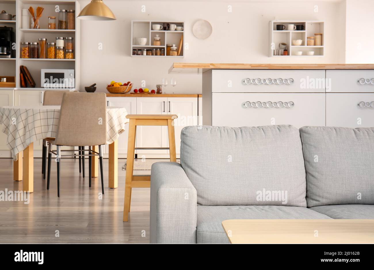Interior of light modern kitchen with white counters, dining table and ...