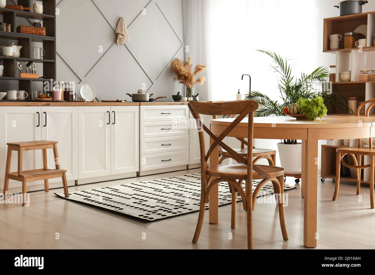 Interior of modern kitchen with white counters, shelving units and ...