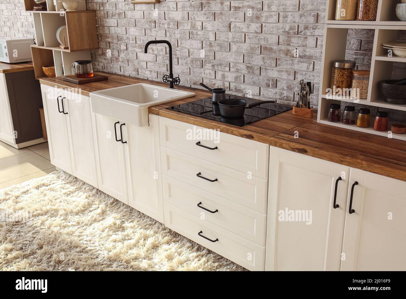 Interior of modern kitchen with white counters, sink and stove Stock ...