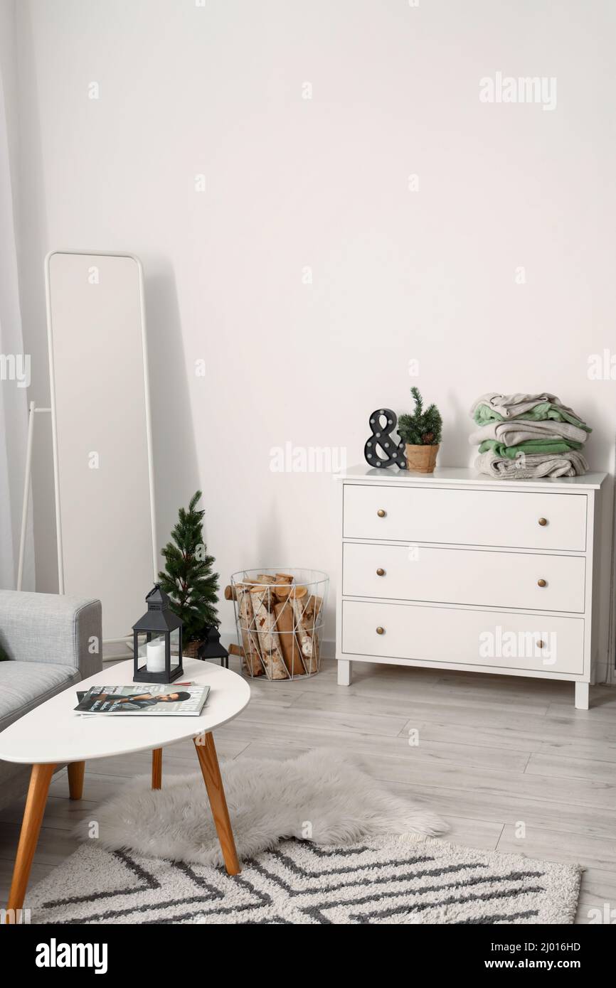 Interior of light living room with mirror, commode and warm sweaters ...