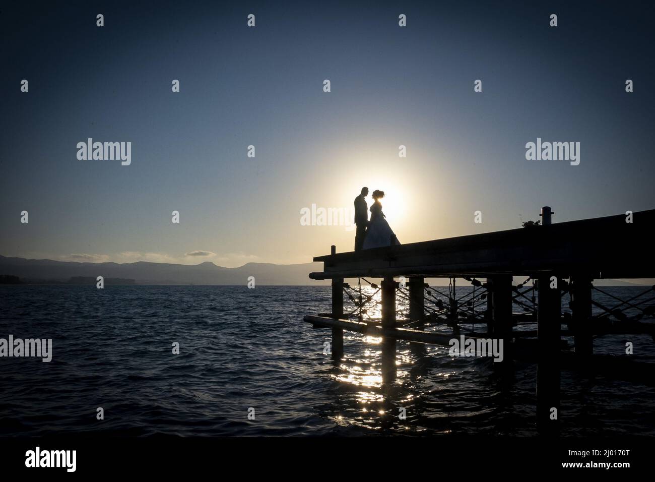 Beautiful view of the bride and the groom standing on the bridge ...