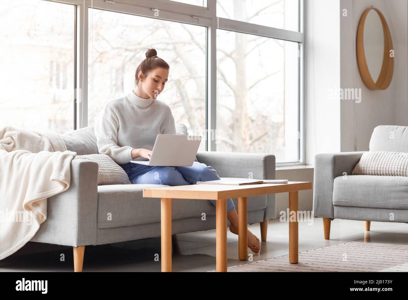 Beautiful young woman with laptop resting on couch at home Stock Photo ...