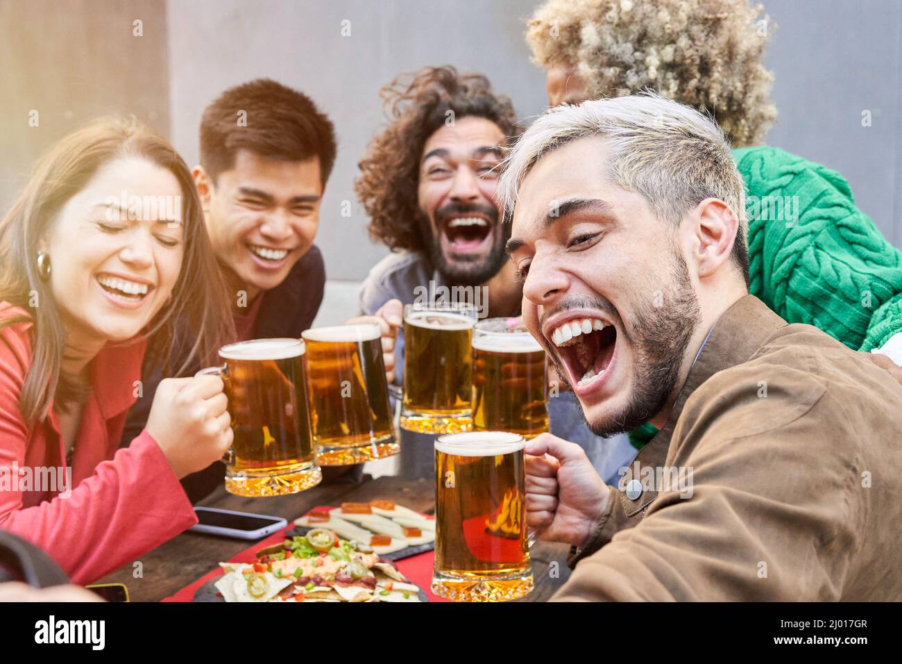 Happy friends taking a selfie at the terrace restaurant drinking beers Stock Photo