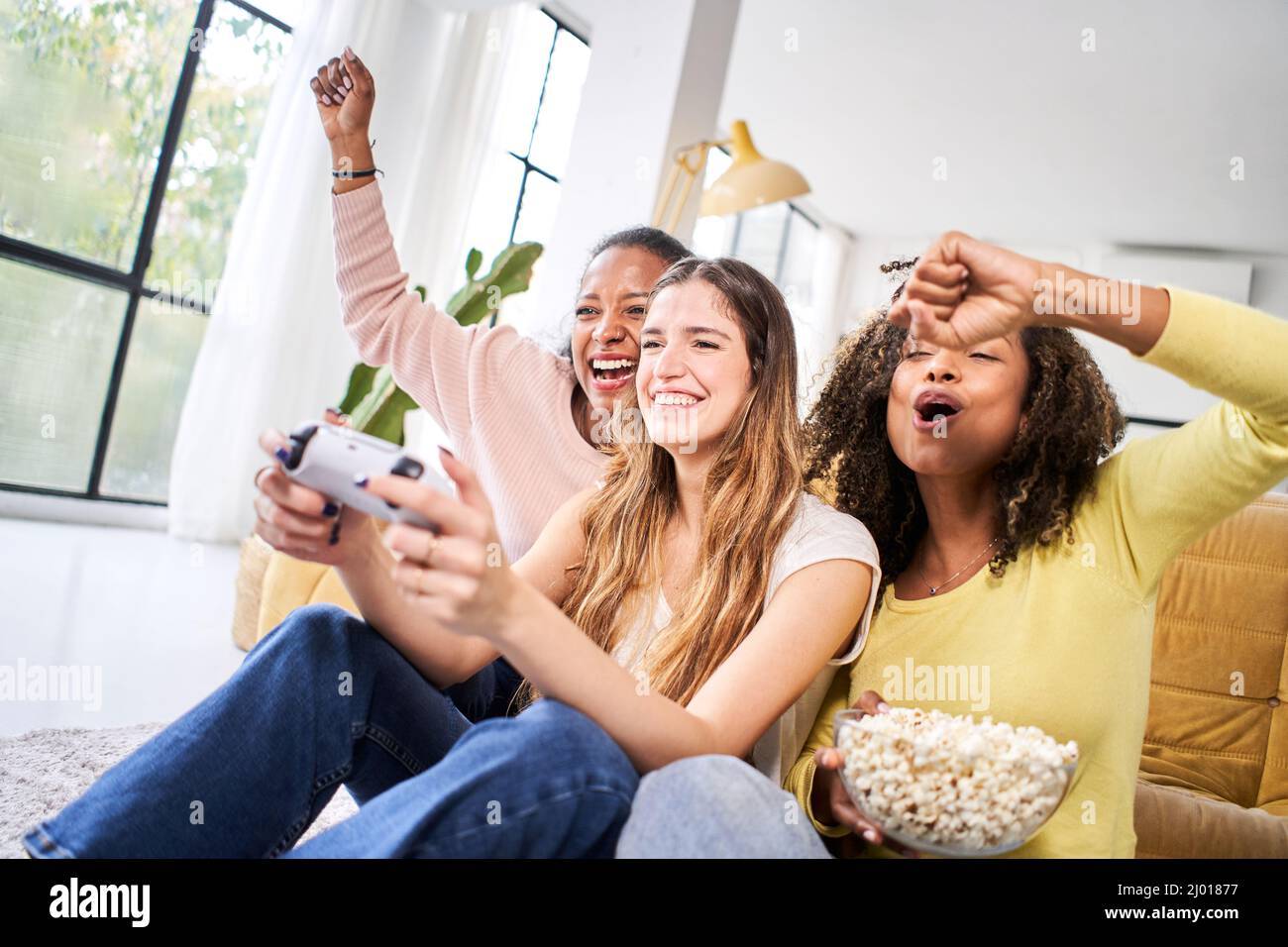 Excited multiethnic teen friends enjoying video games, free time at home, Stock image