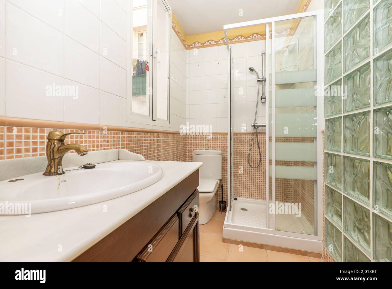 Bathroom with dark wood furniture, white marble countertop, shower