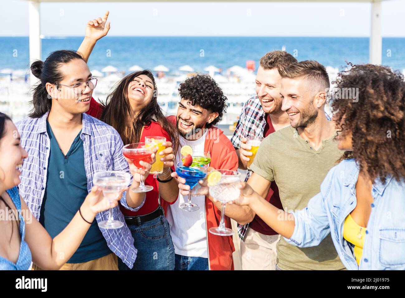 Happy multiracial friends having fun drinking cocktails on summer party Stock Photo