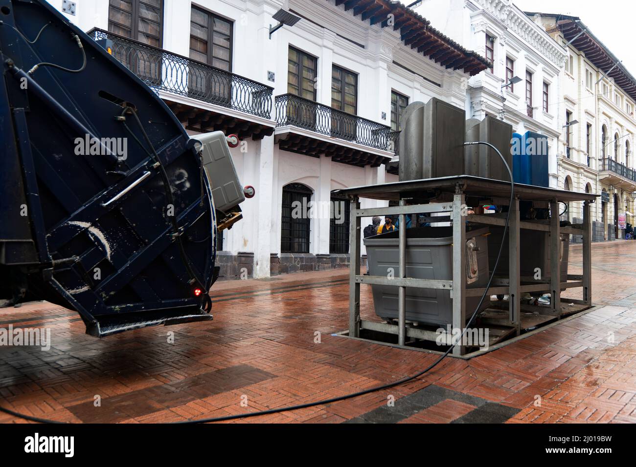Garbage Truck Picking up Trash from Underground Containers in Downtown Quito, Ecuador Stock Photo