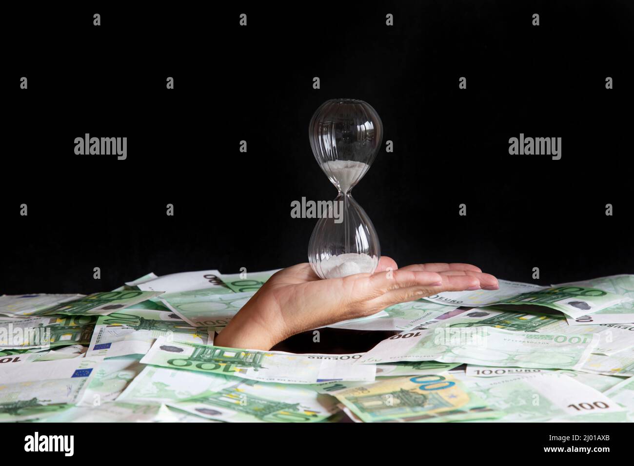 concept time is money, the hand that holds the hourglass climbs out of ...