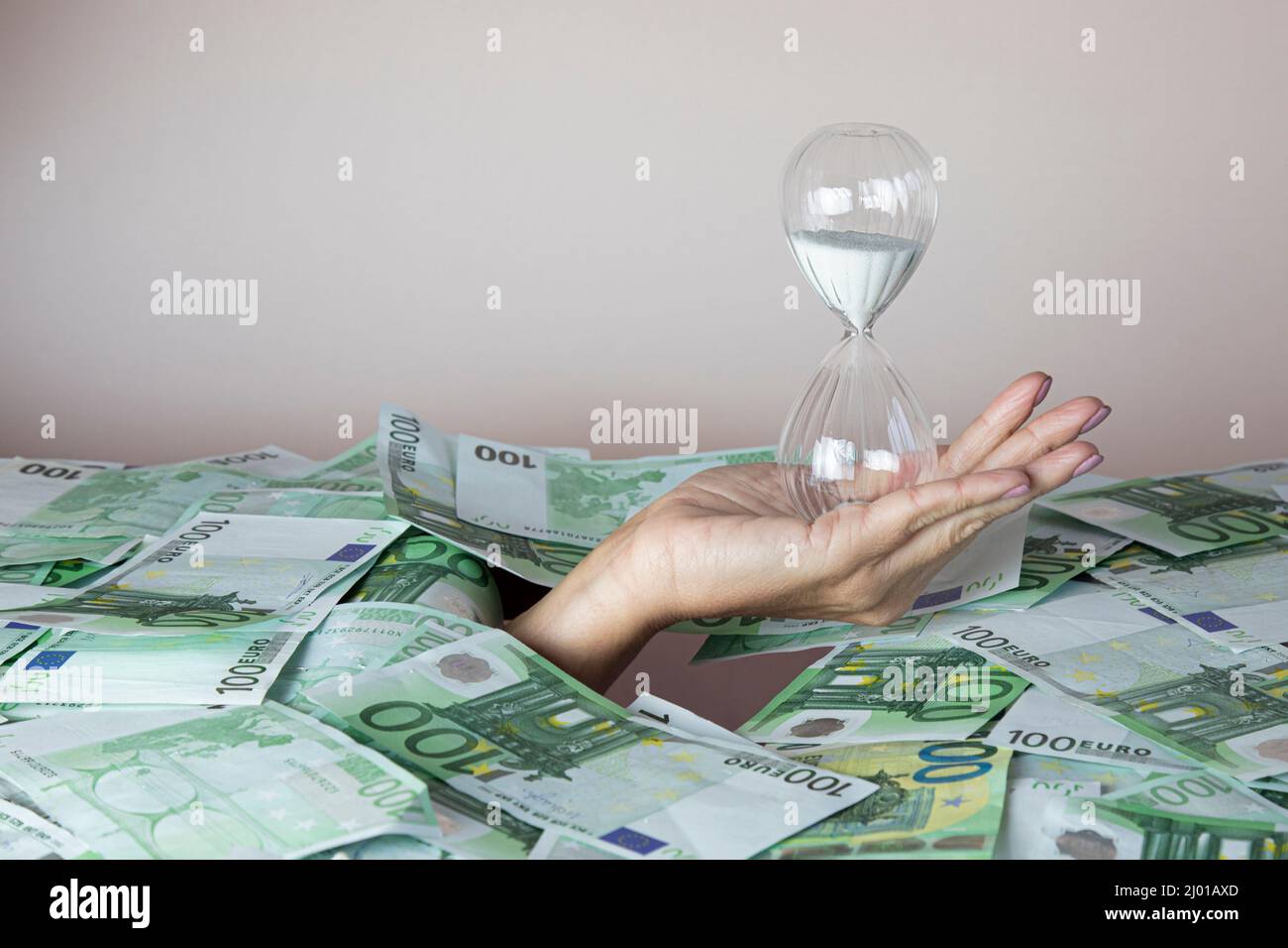 concept time is money, the hand that holds the hourglass climbs out of ...