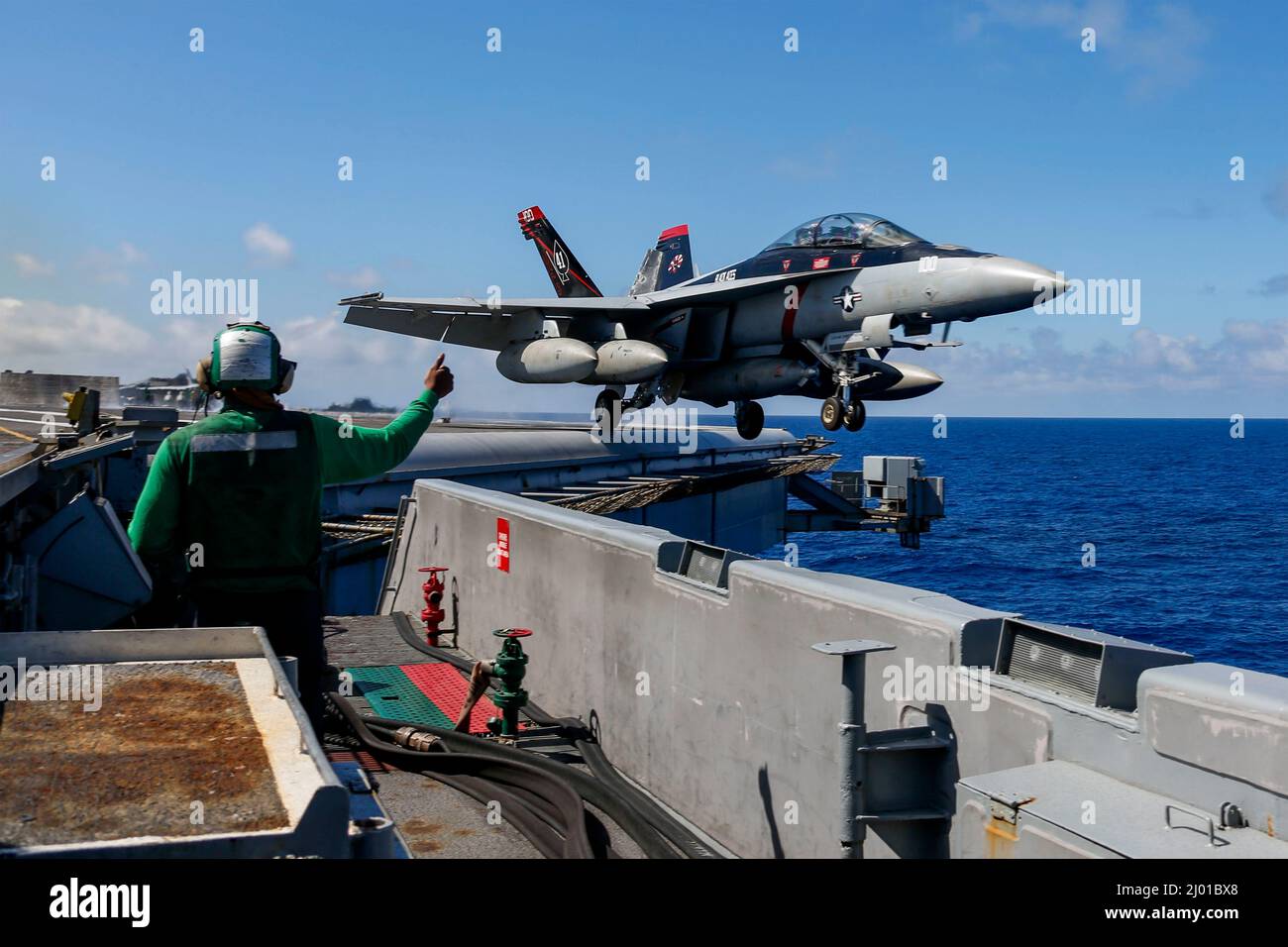 Philippine Sea, United States. 09 February, 2022. A U.S. Navy F/A-18F Super Hornet fighter jet assigned to the Black Aces of Strike Fighter Squadron 41 launches from the flight deck of the Nimitz-class aircraft carrier USS Abraham Lincoln during routine operations, March 9, 2022 in the Philippine Sea.  Credit: MC3 Michael Singley/Planetpix/Alamy Live News Stock Photo