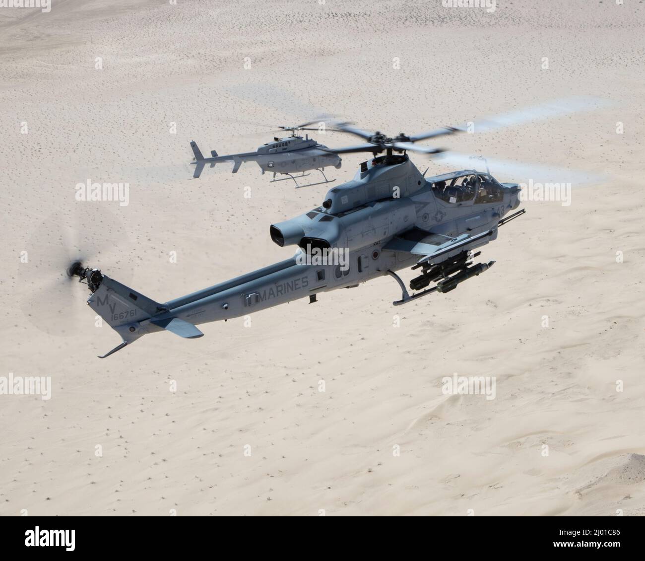 An AH-1Z Viper (front) with Marine Operational and Test Evaluation Squadron 1 (VMX-1), and an MQ-8C Fire Scout unmanned helicopter assigned to Helicopter Sea Combat Squadron 23 (HSC-23), conduct Strike Coordination and Reconnaissance Training near El Centro, California, March 10, 2022. The purpose of this exercise was to provide familiarization and concept development of manned-unmanned teaming. (U.S. Marine Corps photo by Lance Cpl. Jade Venegas) Stock Photo