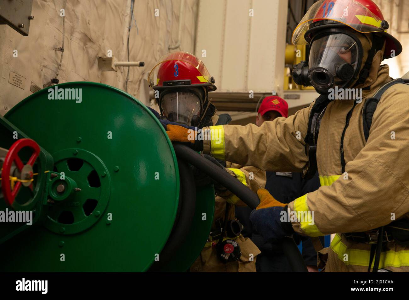 Fireman Urnest Leysath, from Augusta, Georgia, front, and Damage Controlman Fireman Zachary Hill from Pahrump, Nevada, assigned to USS Gerald R. Ford's (CVN 78) engineering department, unroll hose to respond to a simulated fire, March 14, 2022. Ford is in port at Naval Station Norfolk executing a tailored basic phase prior to the ship’s first operational deployment. (U.S. Navy photo by Mass Communication Specialist 3rd Class Jacob Mattingly) Stock Photo