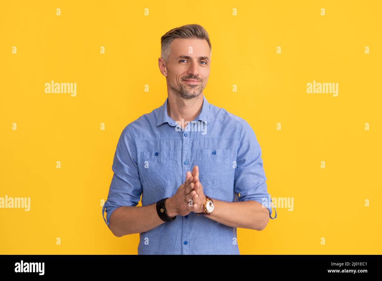 smiling man with wristwatch on yellow background, fashion accessory Stock Photo
