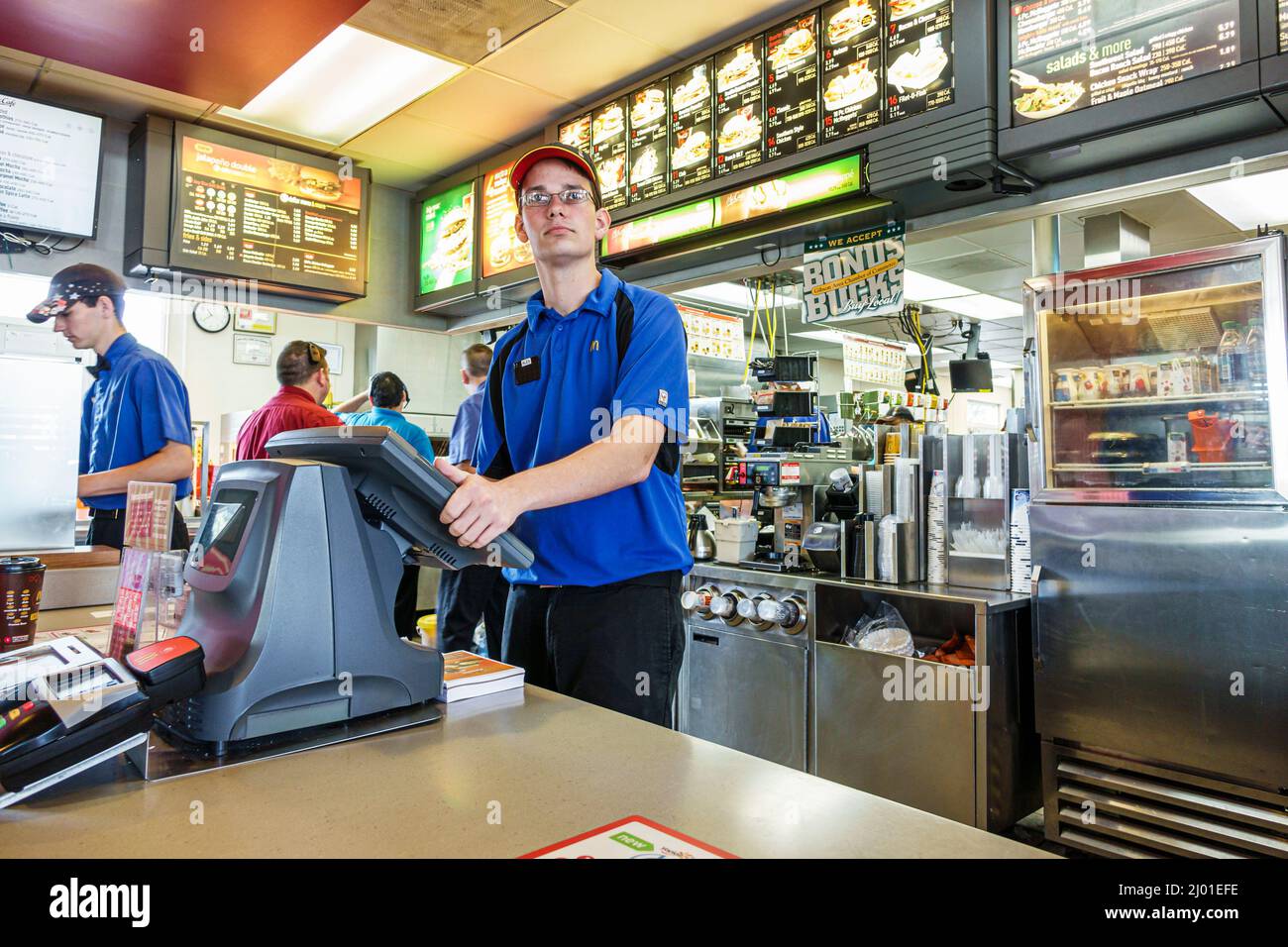 Illinois Gibson City McDonald's fast food restaurant man,employee worker working job uniform order taker cashier,inside interior counter, Stock Photo