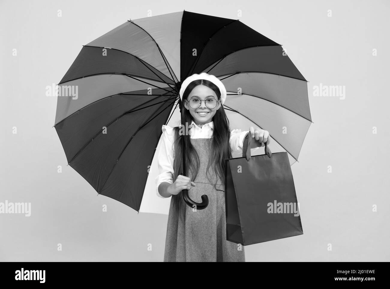 happy teen girl under colorful umbrella in autumn season hold shopping bag, autumn shopping. Stock Photo
