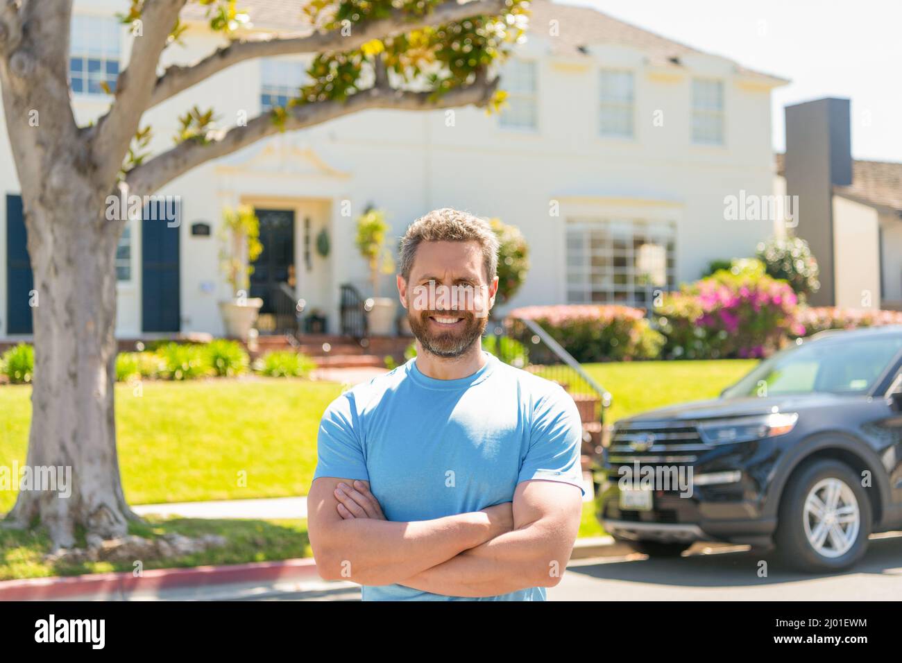 happy dealer man standing next to the car and new house Stock Photo - Alamy