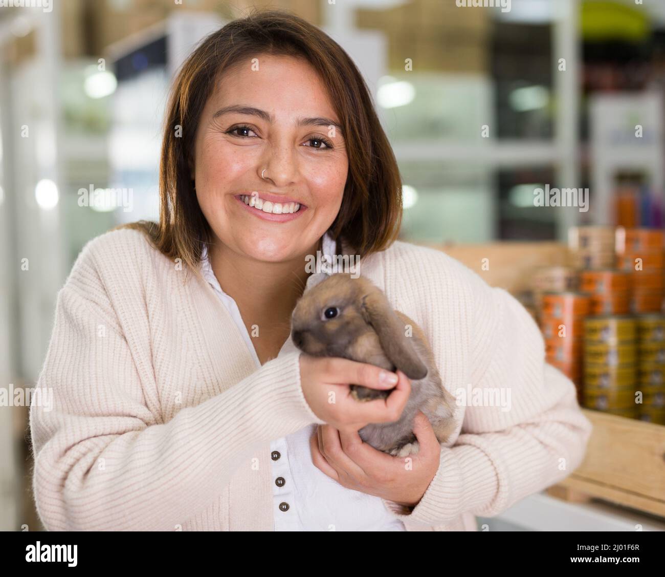 Portrait of cheerful woman holding rabbit in hands Stock Photo - Alamy