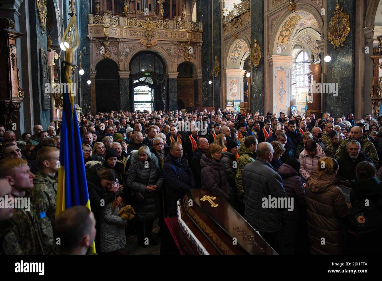 Lviv, Ukraine. 15th Mar, 2022. Civilian mourners attend the funeral service. Three Ukrainian soldiers killed in the March 13th missile attack by Russia at Yavoriv military training ground have been laid to rest. Credit: SOPA Images Limited/Alamy Live News Stock Photo