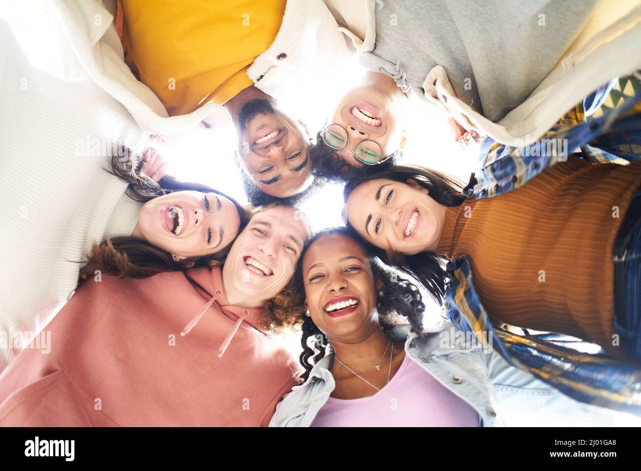 Circle of six happy people looking at the camera embracing and having a fun. Stock Photo
