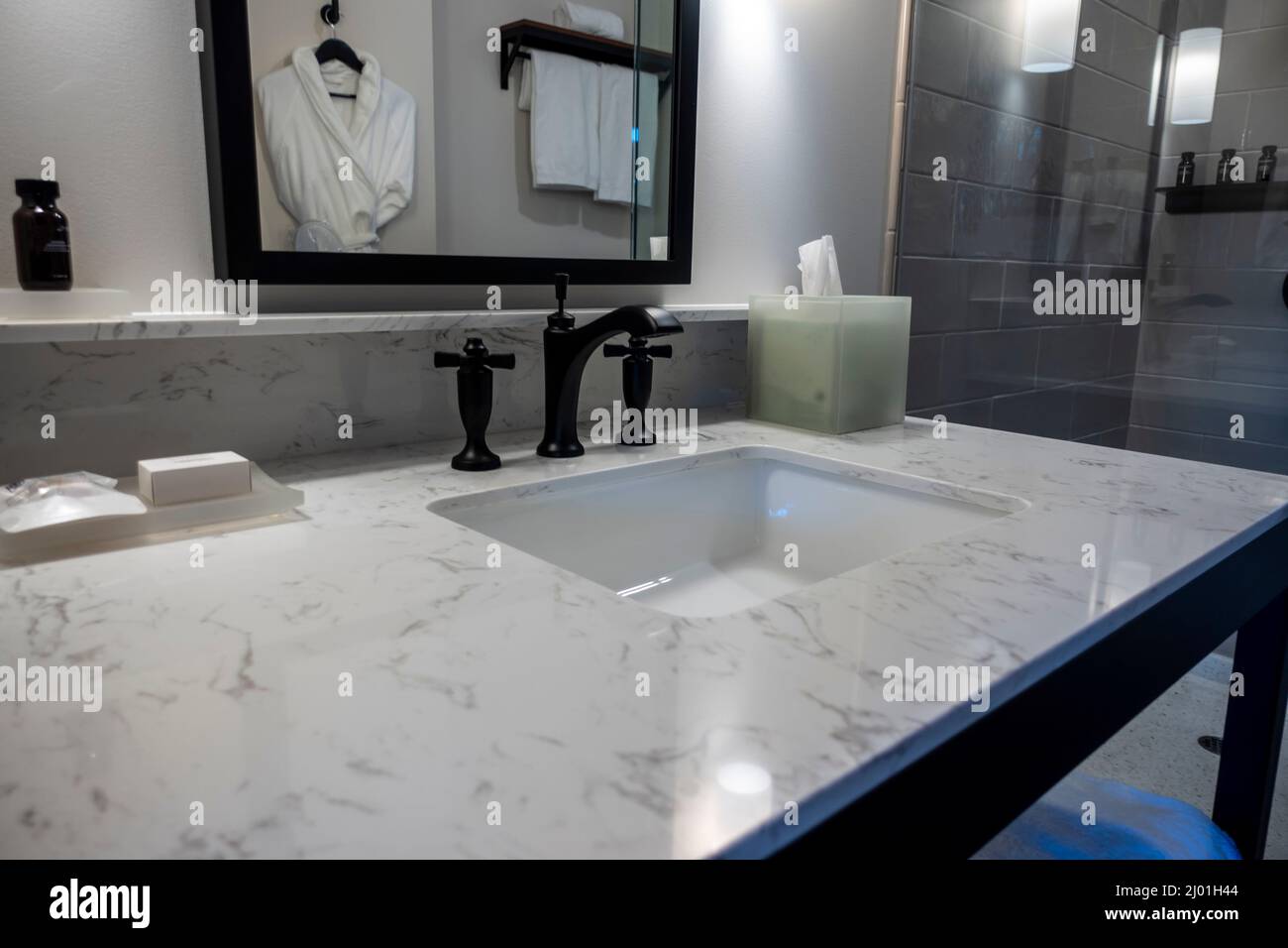 Angled, selective focus on a modern black bathroom sink faucet inside a