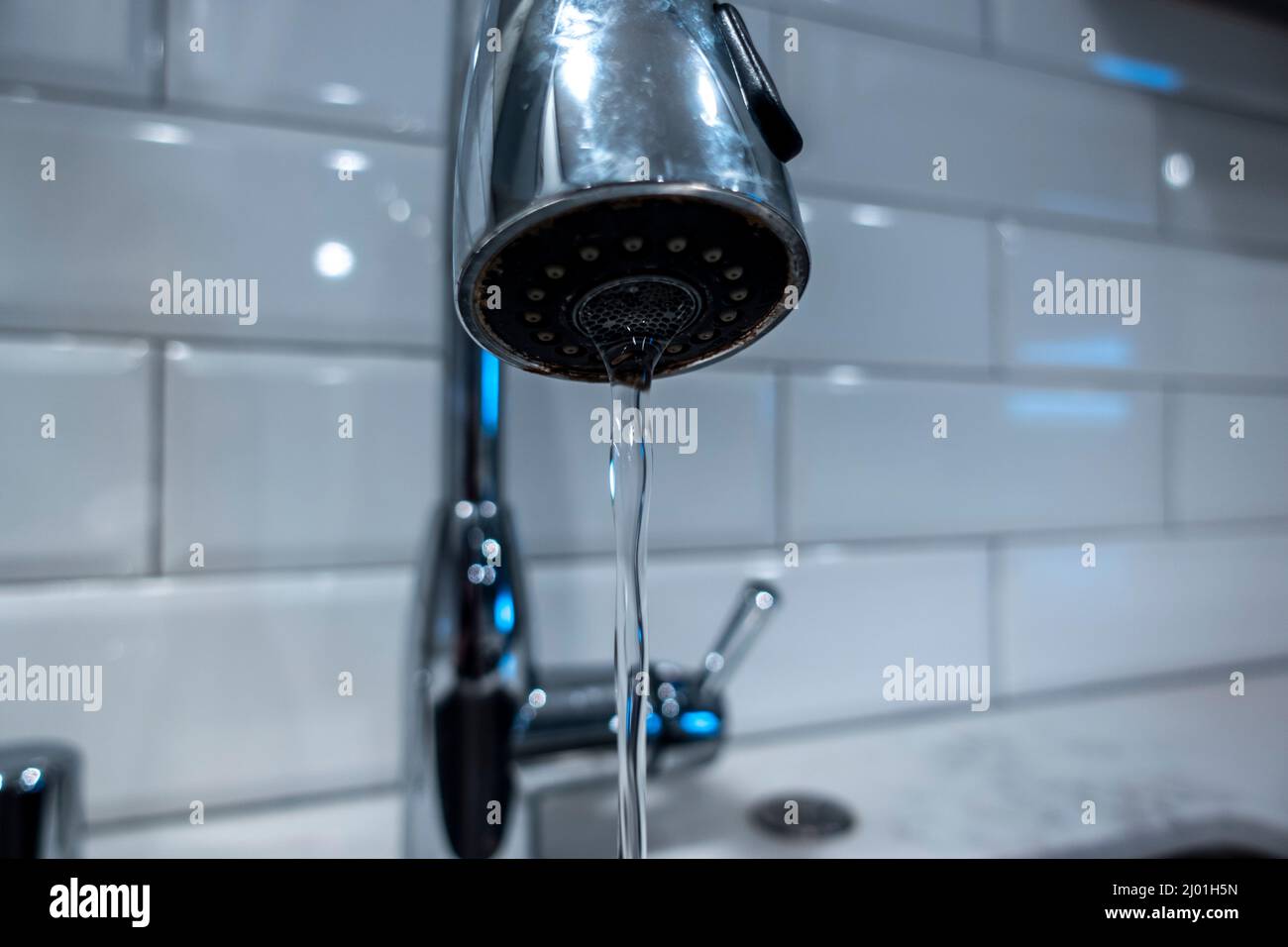 Low angle, selective macro focus on a stainless steel kitchen sink