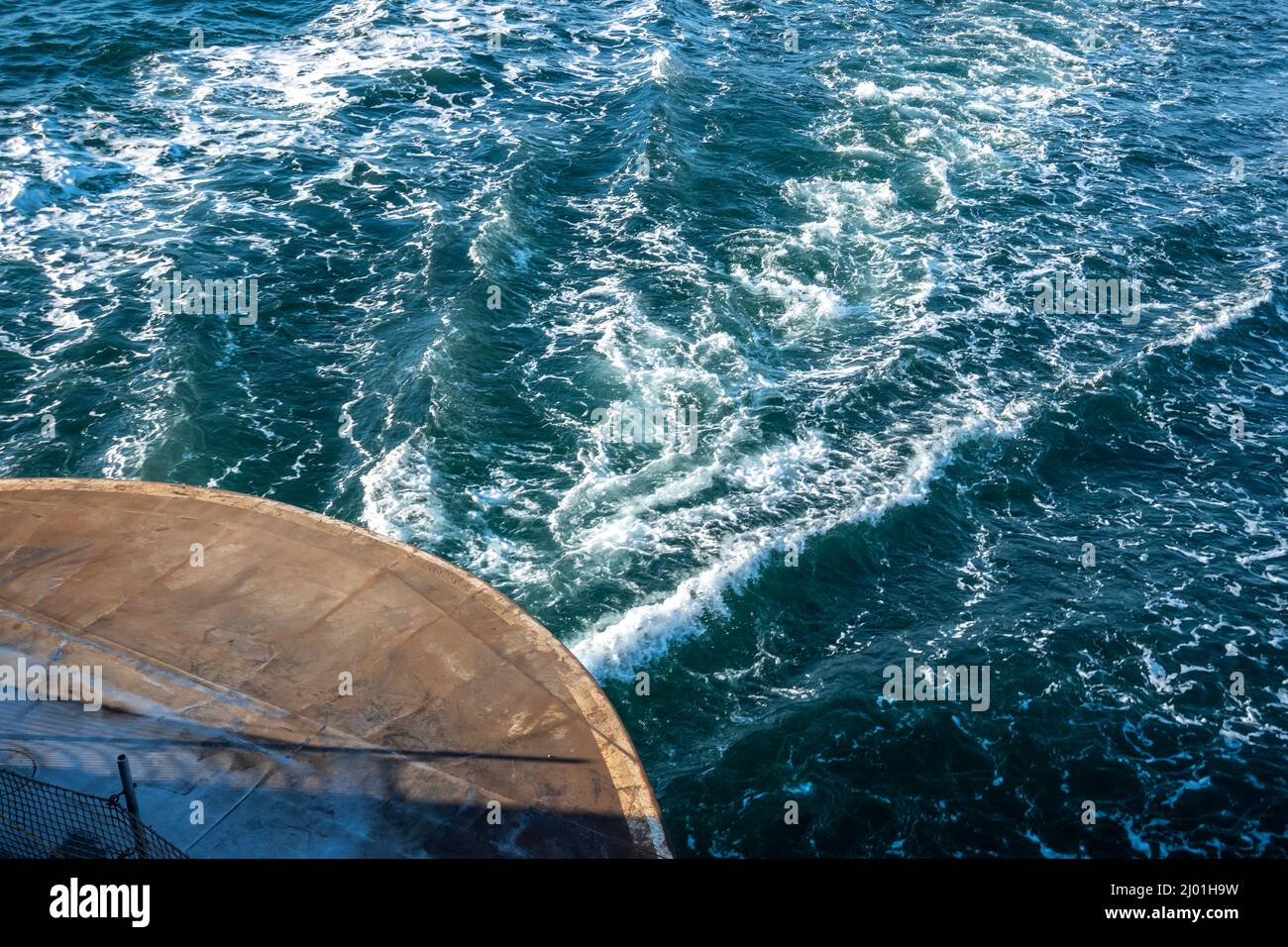 High angle view of the back of a Washington state ferry making its route to San Juan Island, waking the ocean water behind it on an overcast, rainy da Stock Photo