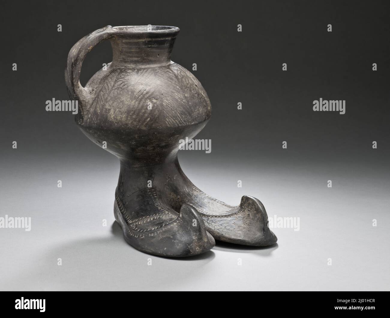 Handled Jar with Boots. Northern Iran, circa 1350-800 B.C.. Furnishings; Serviceware. Black burnished ware Stock Photo