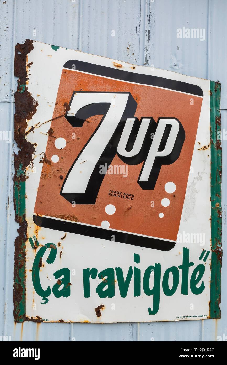 Vintage 7up soft drink company rectangular metal advertising sign for French speaking consumer market posted on exterior wall of garage. Stock Photo