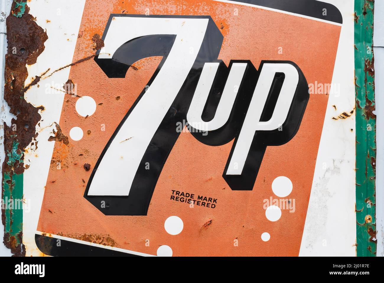 Vintage 7up soft drink company metal advertising sign posted on exterior wall of garage. Stock Photo