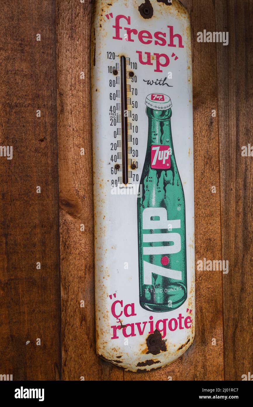 Vinatge 7up soft drink company bilingual French and English metal thermometer advertising sign posted on wood plank wall. Stock Photo