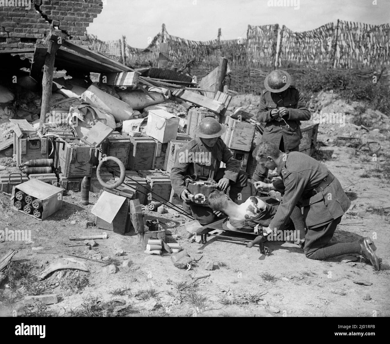 A doctor tending a wounded soldier at a Regimental Aid Post set up in a captured German ammunition dump at Oosttaverne, near Ypres, August 1917. Stock Photo