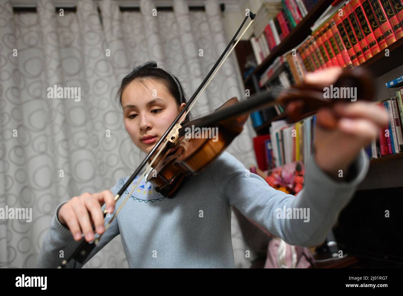 (220316) -- YINCHUAN, March 16, 2022 (Xinhua) -- Ma Yifei plays the Beijing 2022 theme song, Snowflake, on her violin at home in Yinchuan, northwest China's Ningxia Hui Autonomous Region, March 14, 2022. For Ma Yifei, a 16-year-old visually impaired girl, the violin piece of the Beijing 2022 theme song, Snowflake, that she played in the closing ceremony of the Beijing 2022 Paralympic Winter Games, is her best gift for Paralympians across the globe. Ma, a sophomore in Ningxia Special Education High School in northwest China's Ningxia Hui Autonomous Region, lost her eyesight at the age of two Stock Photo